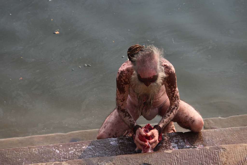 Sadhu a Varanasi mentre lava il suo abito nel Gange - blog di viaggi